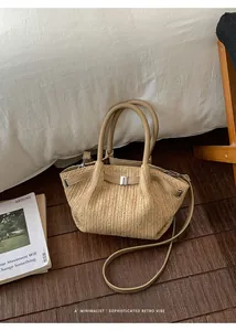 Primer plano de un bolso de paja trenzada minimalista sobre suelo de madera