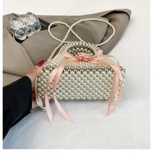 Primo piano della trama di perle e del nastro rosa di questa borsa a secchiello alla moda fatta a mano