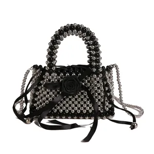 Vista dettagliata di una borsa a mano con perle in acrilico nere e argento fatte a mano
