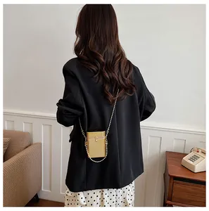 Detailed back view of a stylish gold acrylic box bag with pearl clasp and beaded chain strap