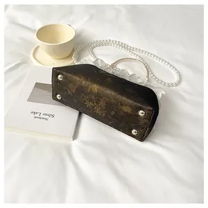 Vista inferior detallada del bolso de moda de estilo chino con patrón dorado y perlas