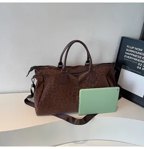 Large leopard print travel duffle bag shown with a green tablet for size reference