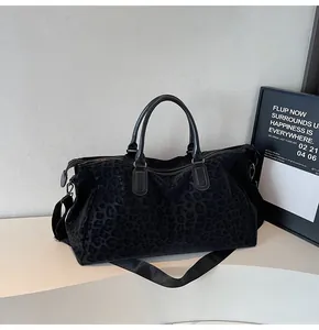 Detail shot of black leopard print travel bag on a modern display table