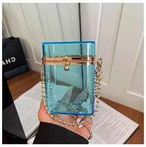 Stylish handheld transparent blue acrylic box clutch bag with gold beaded chain detail.
