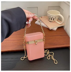 Close-up detail of the pink acrylic box bag featuring a stylish gold bead chain handle