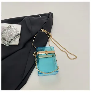 Detail view of blue transparent acrylic box bag with elegant gold bead chain strap