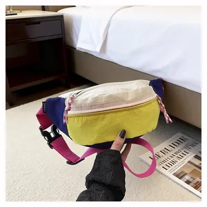 Colorful dopamine style crossbody chest bag held against bedroom background