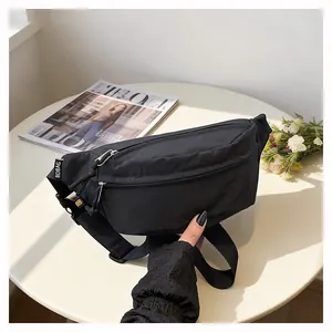 Detailed view of a sleek black nylon fanny pack for women on a stylish white round table