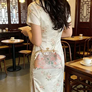 Elegante vintage handtas in Chinese stijl met bloemenpatroon en parelketting.