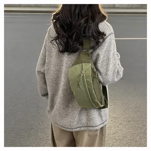 Close-up back view of a woman wearing a trendy green lightweight nylon crossbody chest bag