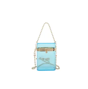 Detailed view of a transparent blue acrylic box bag with golden bead chain handle