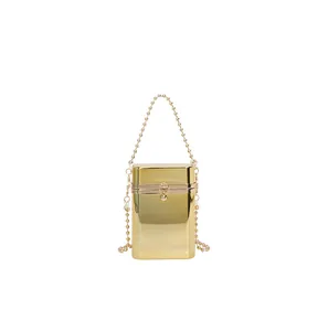 Close-up detail of a mini gold metallic evening box bag with elegant beaded chain straps