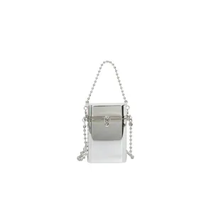 Detailed view of a silver metallic box-shaped handbag with a delicate ball chain strap.