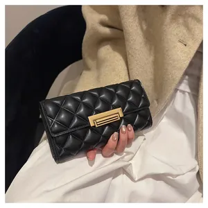 Primer plano detallado del patrón acolchado negro de esta elegante cartera larga mujer