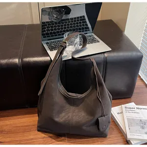 Detail view of a minimalist vintage brown hobo shoulder bag in a lifestyle setting