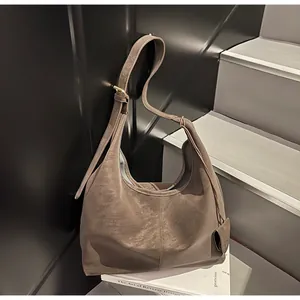 Minimalist vintage brown hobo bag with high-quality textured finish shown on stairs