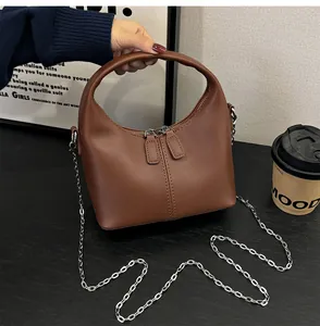 Close-up of vintage brown PU leather handbag with silver chain strap