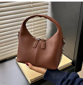 Close-up of a brown minimalist soft PU leather handbag with dual zippers and chain strap.