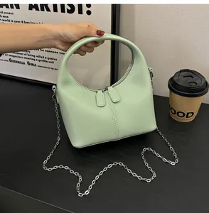 A close-up view of a light green soft PU leather hobo handbag with silver chain strap