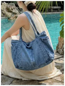 Bolso tote de mezclilla azul grande para mujer mostrado en una relajada escena de piscina