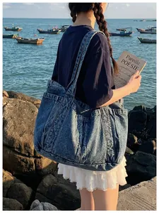 Primer plano de un bolso tote de mezclilla casual para mujer en un entorno costero.