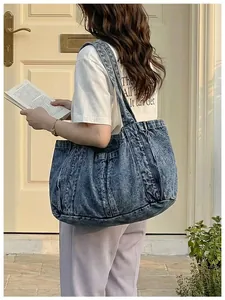 Bolso tote informal de mezclilla azul para mujer usado por una modelo en la calle