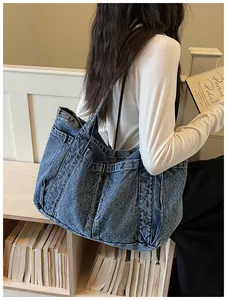 Bolso tote grande de mezclilla azul con bolsillos laterales usado por una modelo