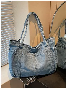 Elegante bolso tote de mezclilla azul claro con diseño multibolsillos en un entorno hogareño