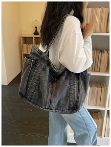 Modelo con un gran bolso tote de tela vaquera negra lavada en una biblioteca real