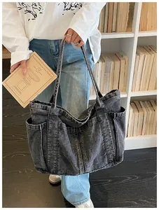 Vista detallada de un bolso tote de mezclilla grande sostenido en una biblioteca