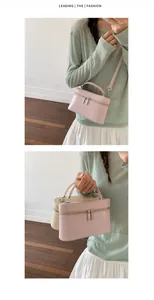 Detail van de stijlvolle roze mini-boxtas met handvat aan de bovenkant en ritsen.