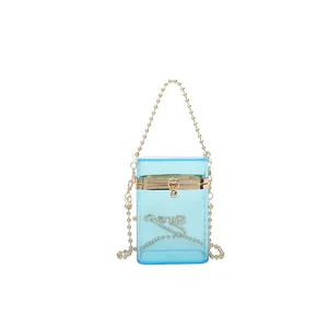 Fashionable light blue transparent acrylic box bag featuring gold ball chain strap handle.