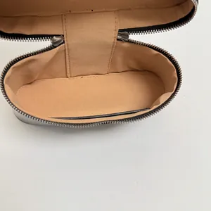 Binnenaanzicht van een modieuze zilveren damesdoostas met beige voering en rits