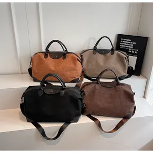 Vintage matte suede duffel travel bags in multiple colors displayed on white steps