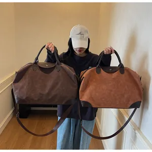 Comparison of two large vintage suede travel bags in brown and tan colors by a model.