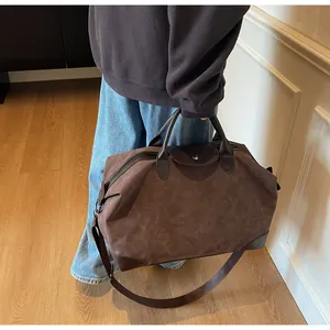 Vintage brown faux suede travel duffel bag with leather handles and adjustable strap