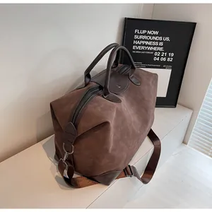 Side view of a premium retro brown matte suede travel duffle bag with shoulder strap