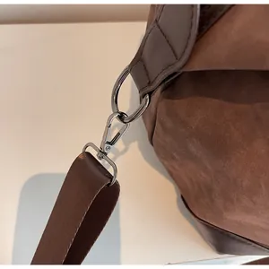 Close-up of the high-quality metal clasp and suede texture on vintage travel bag