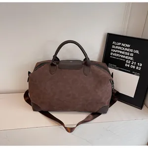 Vintage brown suede travel bag with leather handles shown in a lifestyle setting