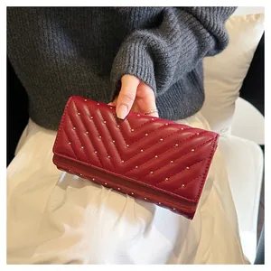Vista dettagliata di un portafoglio rosso da donna alla moda con trapuntatura a V e borchie