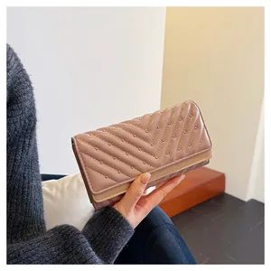 Vista dettagliata di un portafoglio in pelle rosa trapuntata con borchie dorate