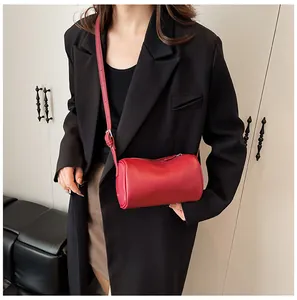 Stylish model wearing a minimalist red PU leather cylinder pillow bag in vintage style