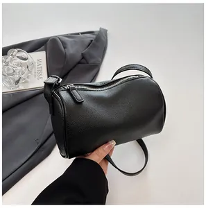 Detailed macro shot of a minimalist black pebbled PU leather barrel pillow bag for women