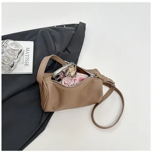Close-up of brown PU leather pillow bag showing interior capacity and accessories