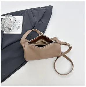 Detail of minimalist khaki PU leather pillow bag with top zipper and interior lining