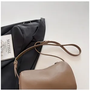 Detailed macro view of a brown pebble-textured pillow bag with an adjustable strap