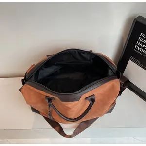 Close-up view of the spacious black interior lining of this brown travel duffel bag.