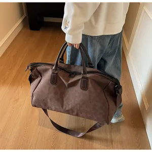 Sac de voyage marron pour voyages d'affaires tenu par une personne dans un décor moderne