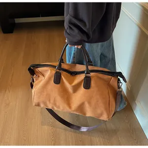 Une personne tenant un grand sac de voyage marron dans un intérieur très élégant