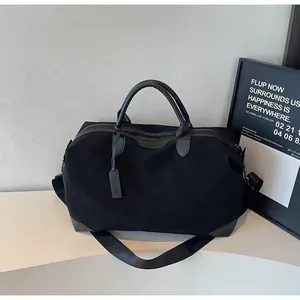 Detailed view of a large black Korean-style travel duffel bag with handles and strap.